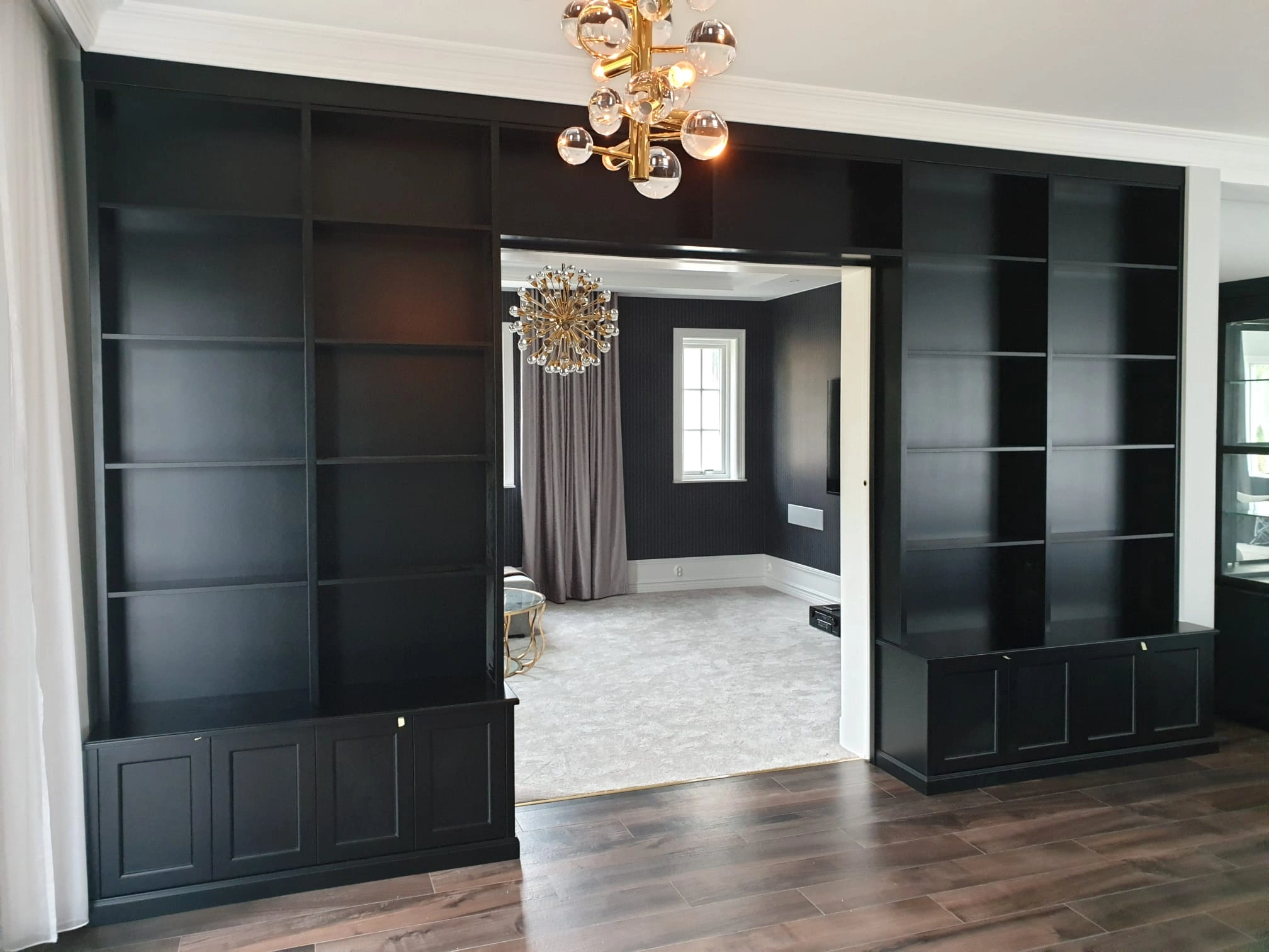 Svart bokhylla med genomgång