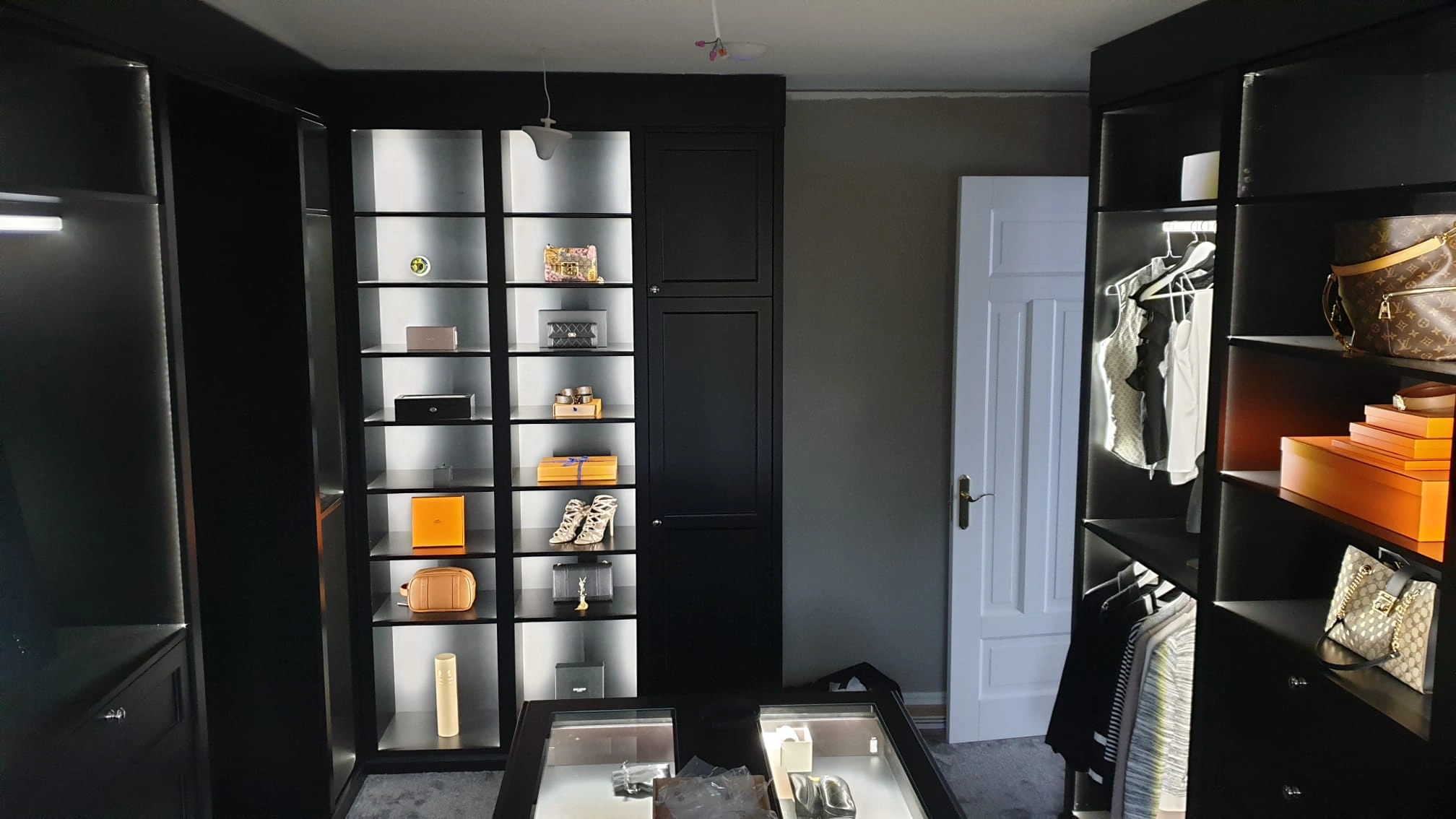 Svart walk-in closet med designerväskor