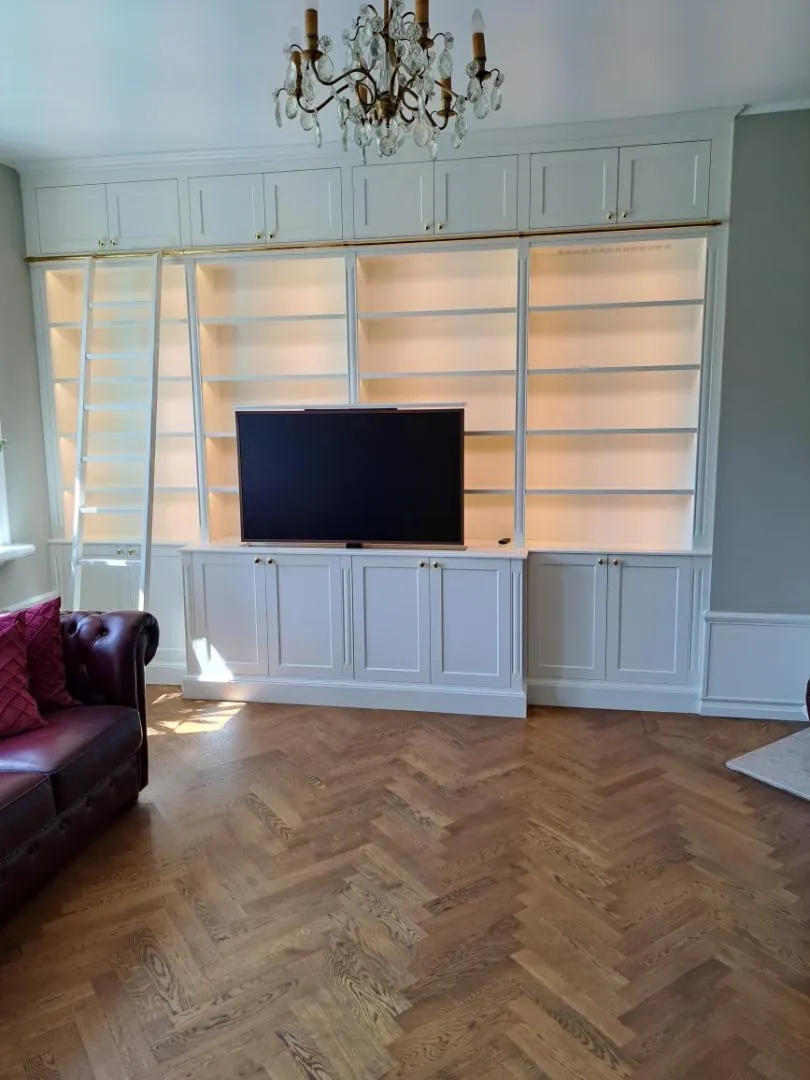 Vit bokhyllvägg med TV